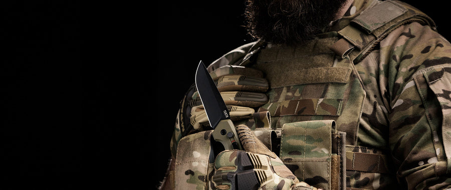 A3 Delta automatic knife held in a gloved hand against a dark background