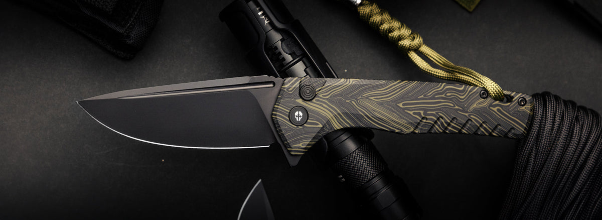 TEKTO F3 Charlie folding knife with a Damascus G10 handle beside a flashlight on a dark background