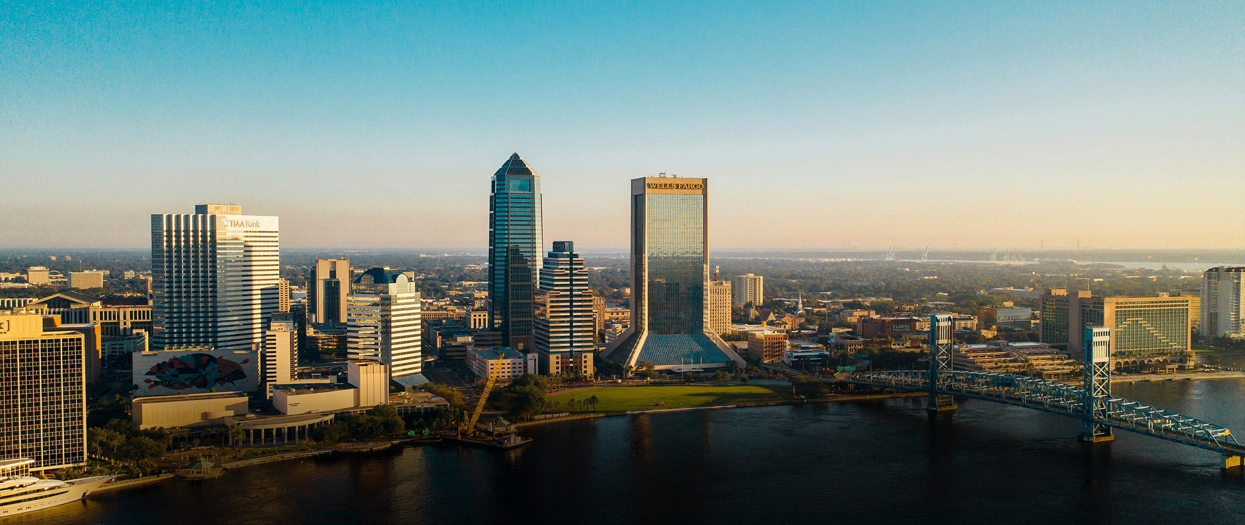 City skyline with tall buildings and a river in the foreground in Florida