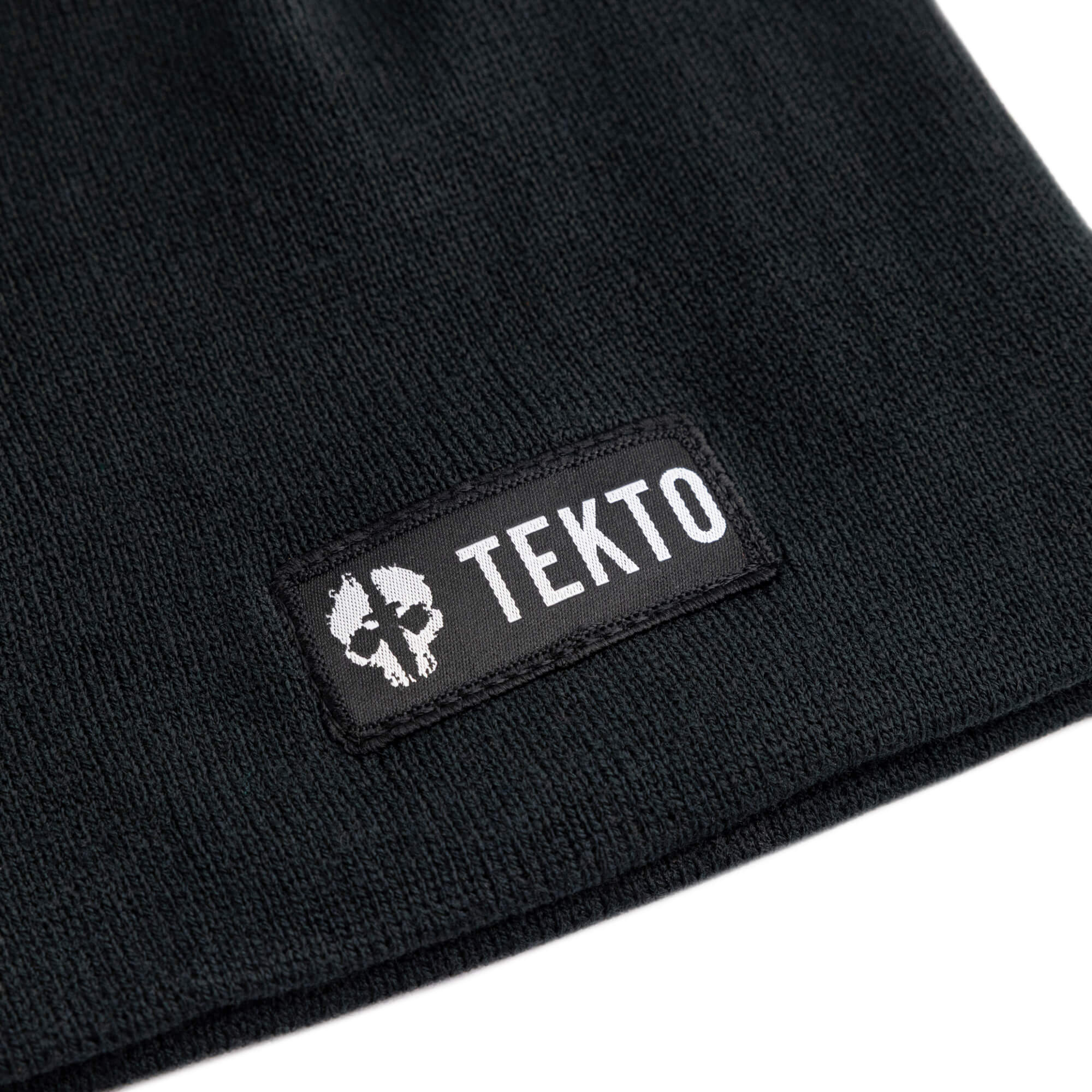 black beanie with a tekto logo on a white background