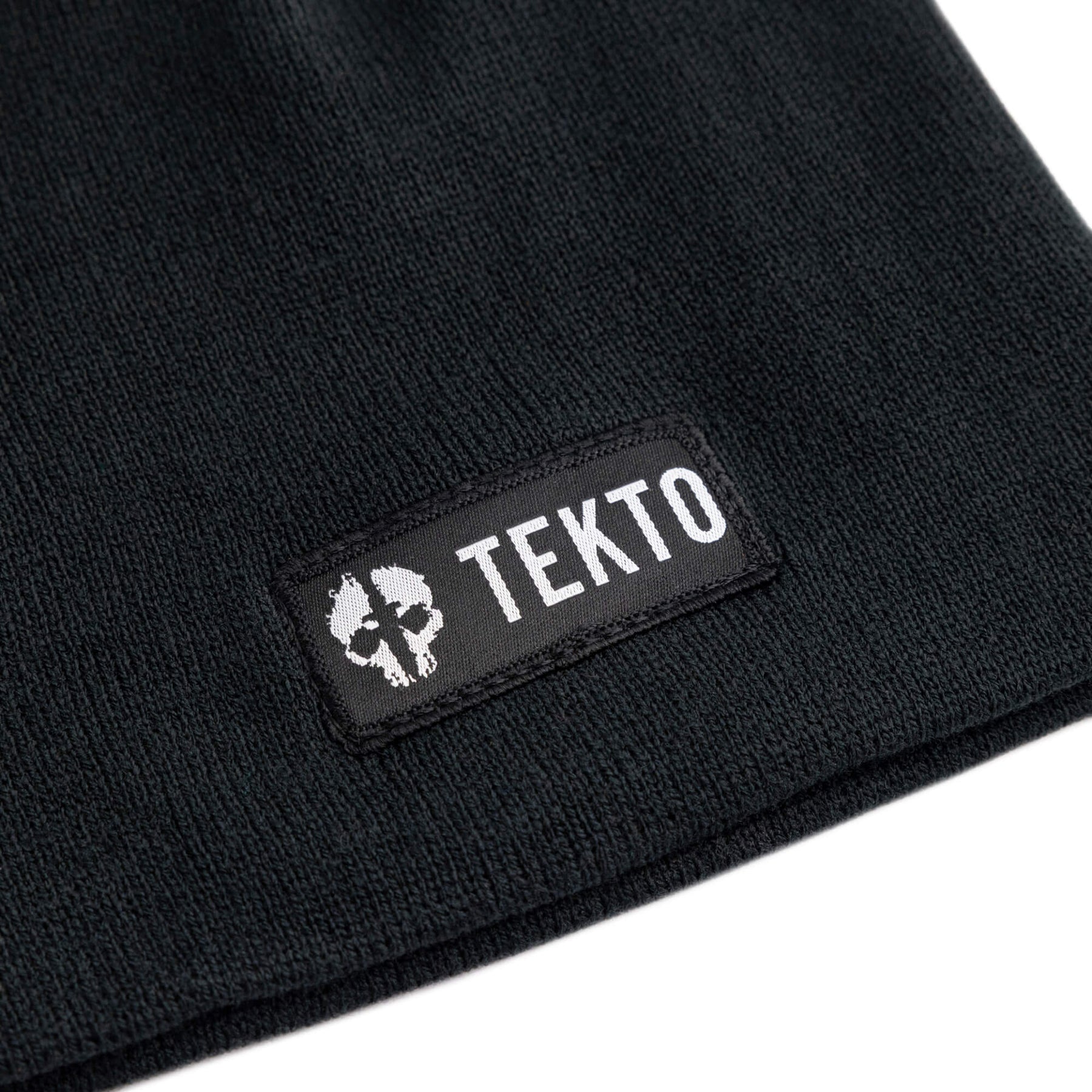 black beanie with a tekto logo on a white background