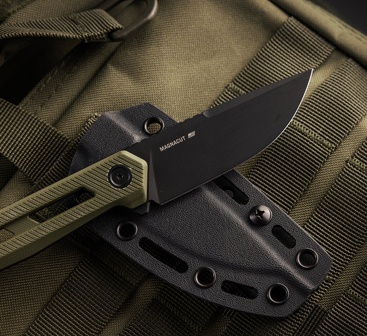 TEKTO X1 Atlas fixed blade with an olive handle in a black sheath on an olive green pack